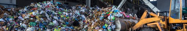 excavator stacks trash in big pile at sorting modern waste recyc